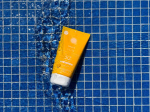Speick Sun: breite, gelbe Tube mit blauem Pool im Hintergrund