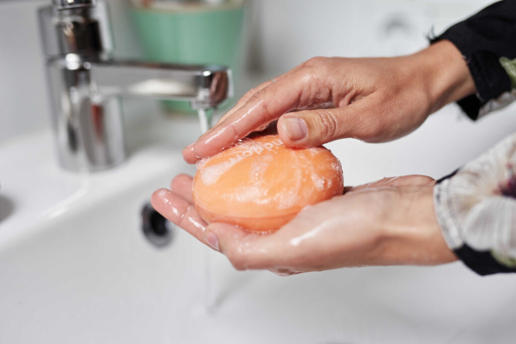 rundes Seifenstück wird mit der Hand aufgeschäumt